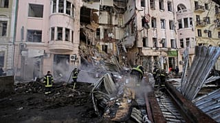 Firefighters extinguish an apartment house after a Russian rocket attack in Kharkiv
