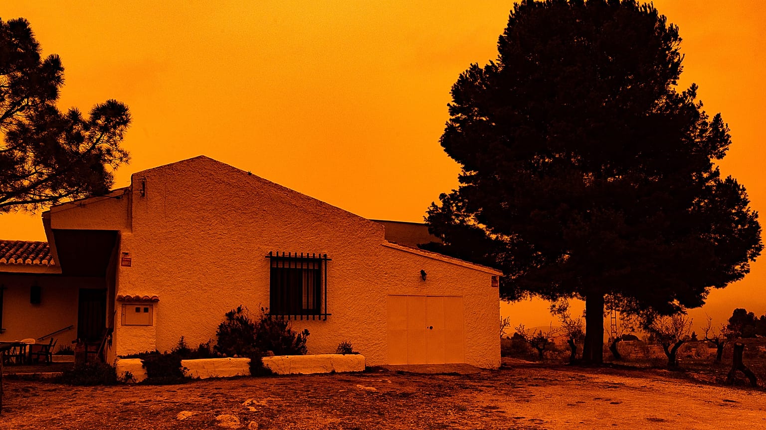 An orange sky is seen over a building in Navares, south eastern Spain on Monday.