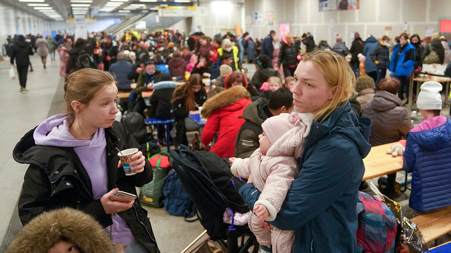 Two women with their children rest in a subway hall after fleeing from the Ukraine at the main train station in Berlin