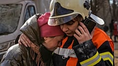 Eine Feuerwehrfrau tröstet eine Bewohnerin nach der Bombardierung eines Viertels in Kiew.