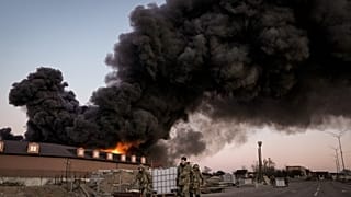 جنود أوكرانيون يحملون حاويات بعد قصف مستودع بالقرب من كييف، أوكرانيا