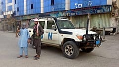 مقاتلو طالبان يلتقطون صورة بجوار مركبة تابعة للأمم المتحدة في قندوز بأفغانستان.