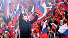 Vladimir Poutine salue la foule après son discours au stade olympique de Moscou, le 18 mars 2022