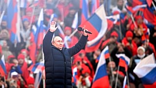 Vladimir Poutine salue la foule après son discours au stade olympique de Moscou, le 18 mars 2022