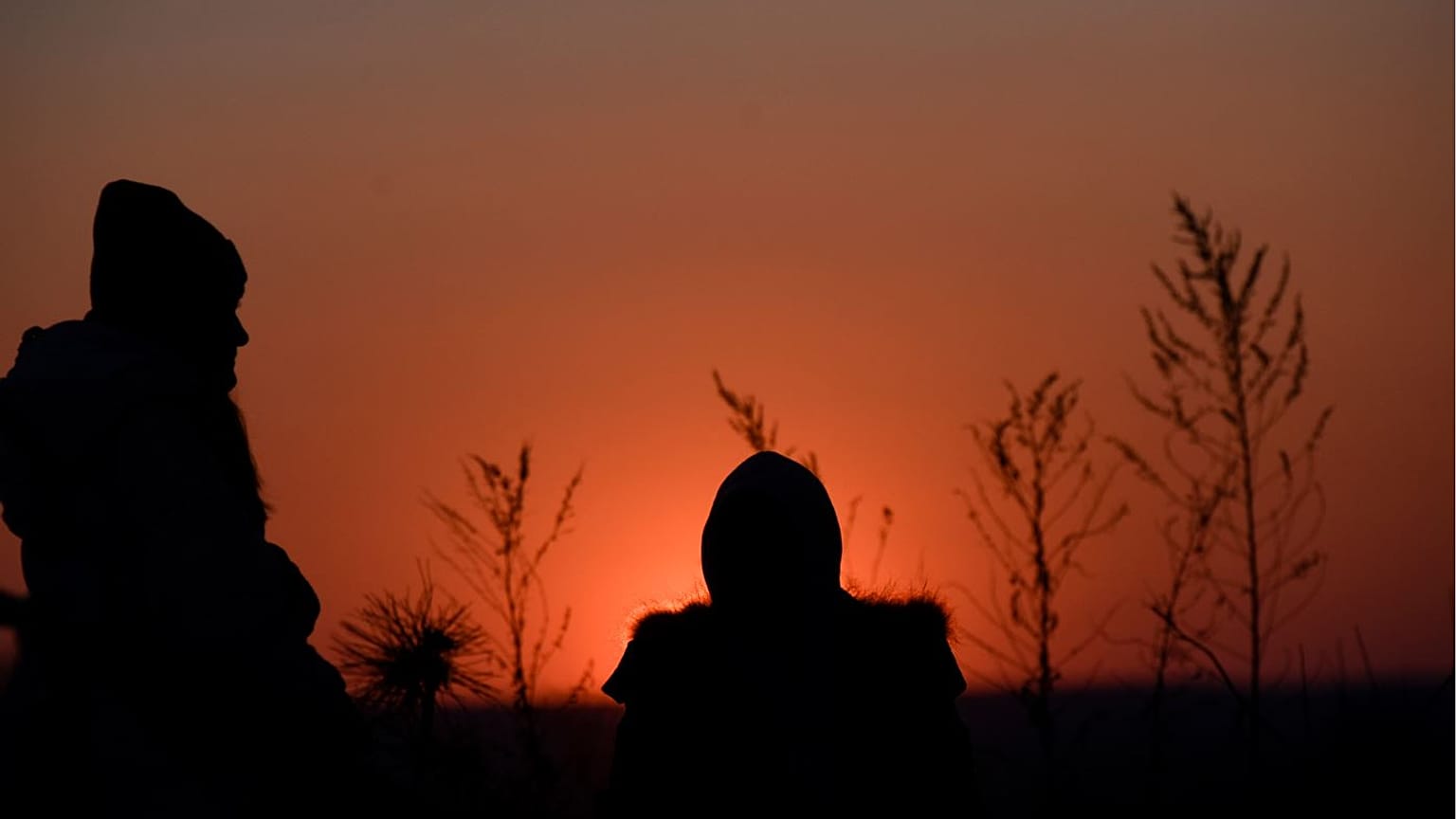 Ukrainian evacuees wait for relocation as the sun goes down after crossing the Ukrainian-Romanian border in Siret, northern Romania