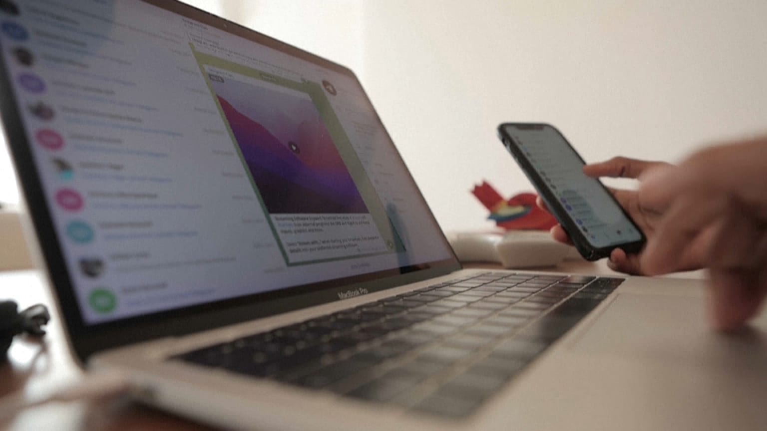 Una usuaria de la plataforma Telegram maneja su móvil y ordenador