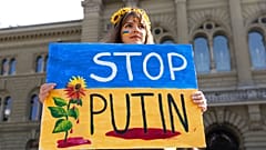 A Protester holds a "Stop Putin" banner 
