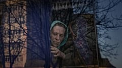 امرأة تنتظر في حافلة للشرطة الأوكرانية لفحص الأوراق والممتلكات في بروفاري - أوكرانيا. 2022/03/20