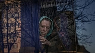 امرأة تنتظر في حافلة للشرطة الأوكرانية لفحص الأوراق والممتلكات في بروفاري - أوكرانيا. 2022/03/20