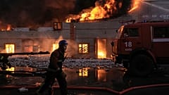 Los bomberos ucranianos extinguen un incendio en un almacén tras un bombardeo en Kiev, Ucrania, el  17 de marzo de 2022. 
