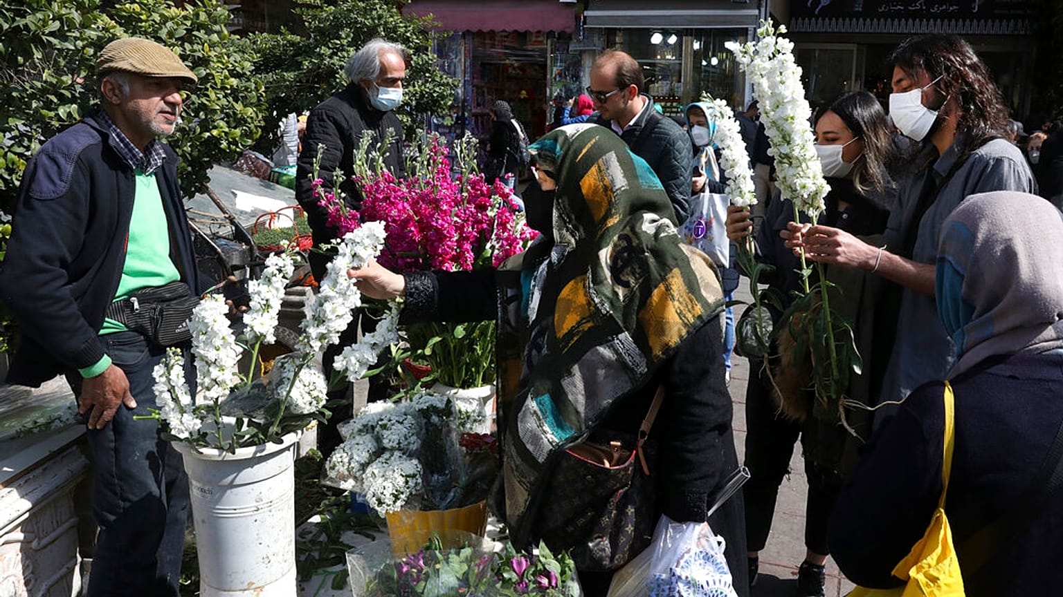 Des gens achètent des fleurs pour le Nouvel An sur la place Tajrish, dans le nord de Téhéran, en Iran, samedi 19 mars 2022.