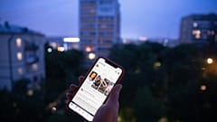 مستخدم يحمل هاتفًا ذكيًا يتصفح فيسبوك في موسكو، روسيا.