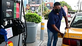 Un taxista llena el depósito de combutible en Panamá
