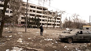 El fotógrafo de Associated Press Evgeniy Maloletka se encuentra entre los escombros de un ataque aéreo contra una universidad de Mariúpol, el jueves 10 de marzo