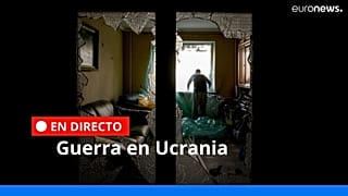 Un hombre cubre la ventana destrozada de su salón con una lámina de plástico en un edificio dañado por un bombardeo en Kiev, Ucrania, 21/3/2022.