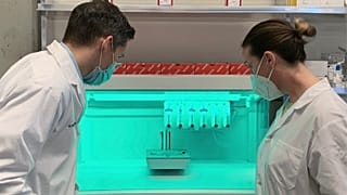 Dr. Ryan Flannigan and research assistant Meghan Robinson observe a 3D bioprinter in their lab at the University of British Columbia.
