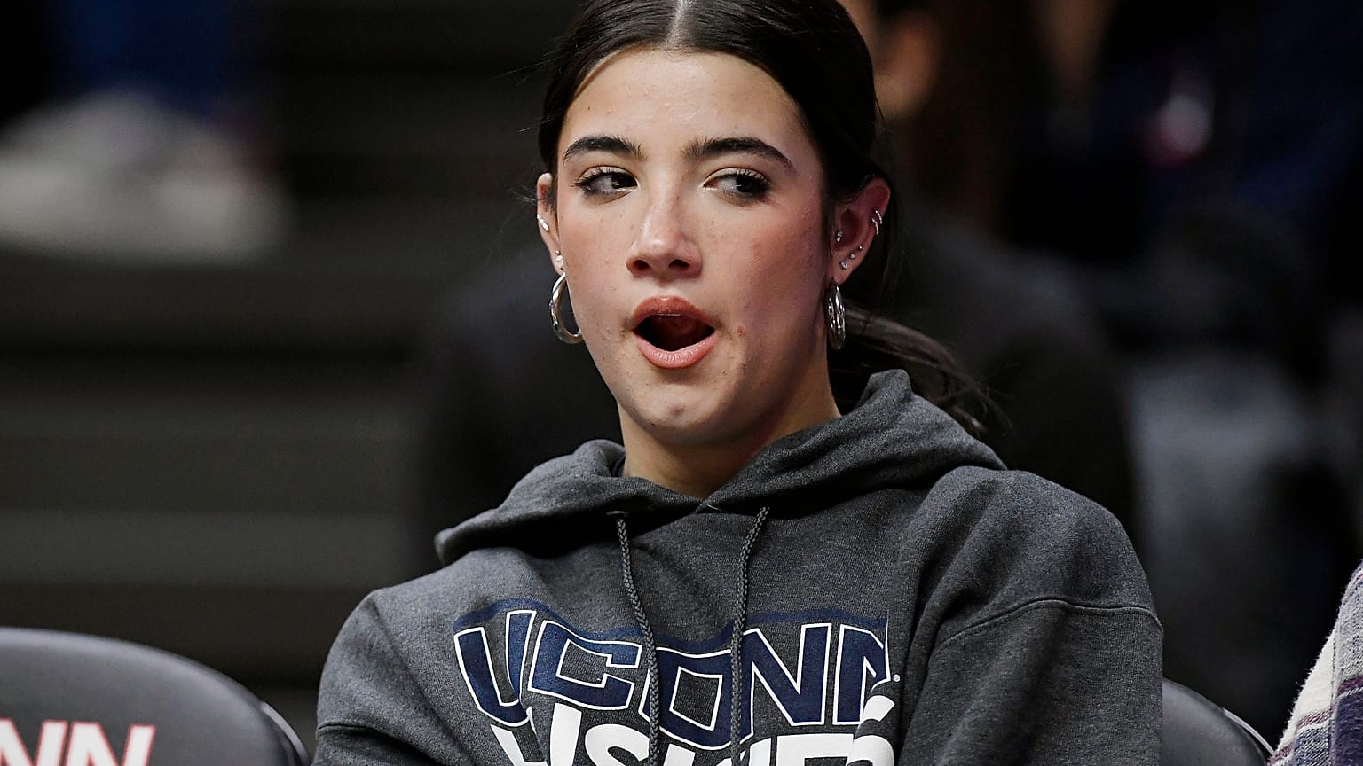 TikTok star Charli D'Amelio yawns during an NCAA college basketball game between Connecticut and Seton Hall, Wednesday, Feb. 16, 2022.