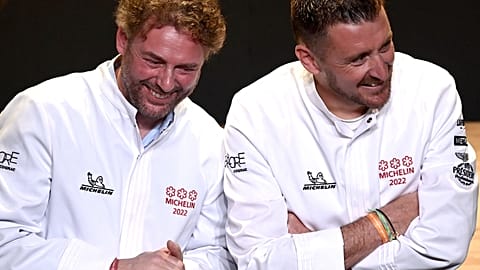 French chefs Arnaud Donckele (L) and Dimitri Droisneau (R) celebrate after being awarded a third Michelin star during the 2022 edition of the Michelin guide