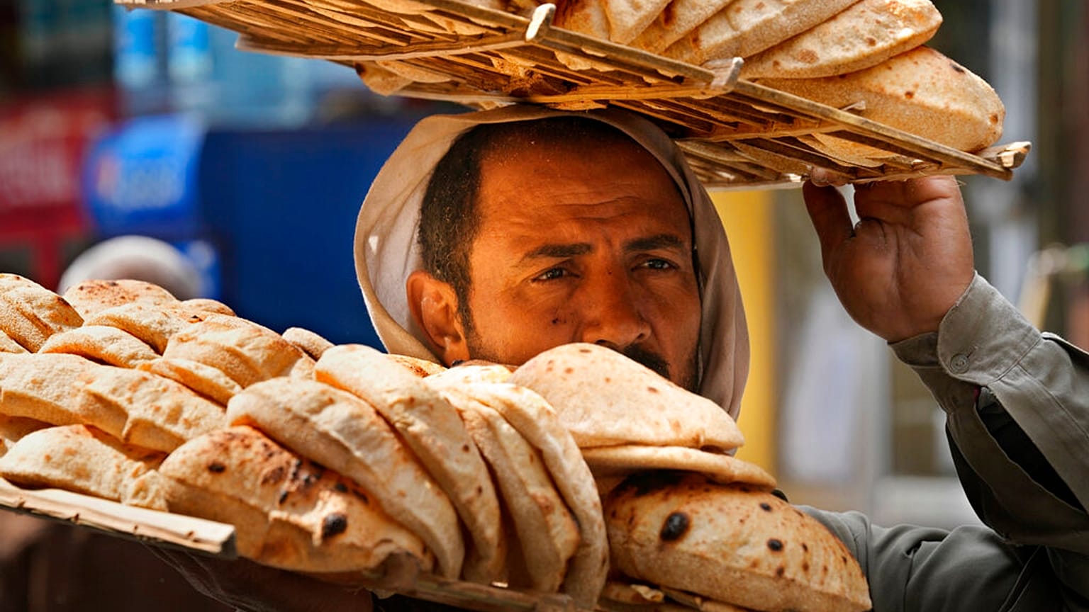 بائع يحمل صينية الخبز "البلدي" المصري التقليدي، بحي القاهرة القديمة في القاهرة، مصر، الثلاثاء 22 مارس 2022