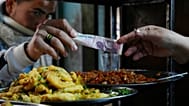 FILE: A man buys food at a popular restaurant in Cairo, Egypt, 22 March 2022