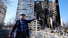 Un homme montre son appartement détruit après le bombardement d'un immeuble à Kharkiv, ce jeudi