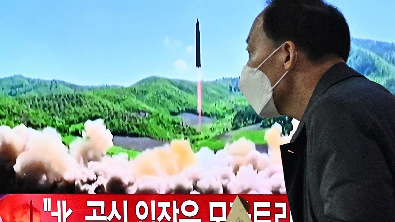 Un homme passe devant un écran de télévision à Séoul (Corée du Sud), le 24 mars 2022