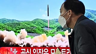 Un homme passe devant un écran de télévision à Séoul (Corée du Sud), le 24 mars 2022