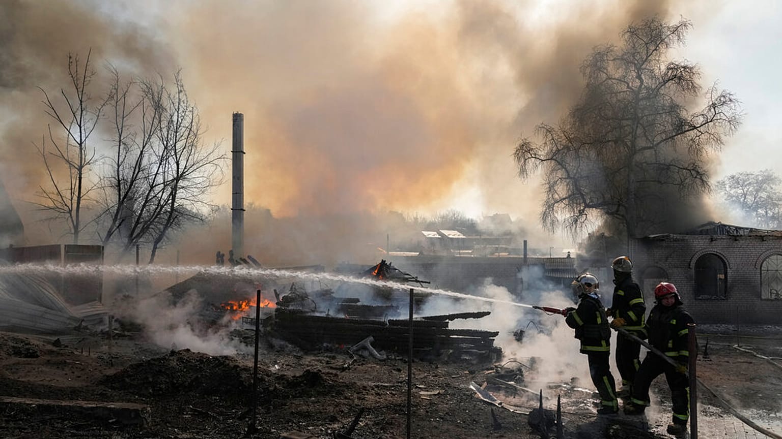 Tűzoltók egy bombázás után Ukrajnában.