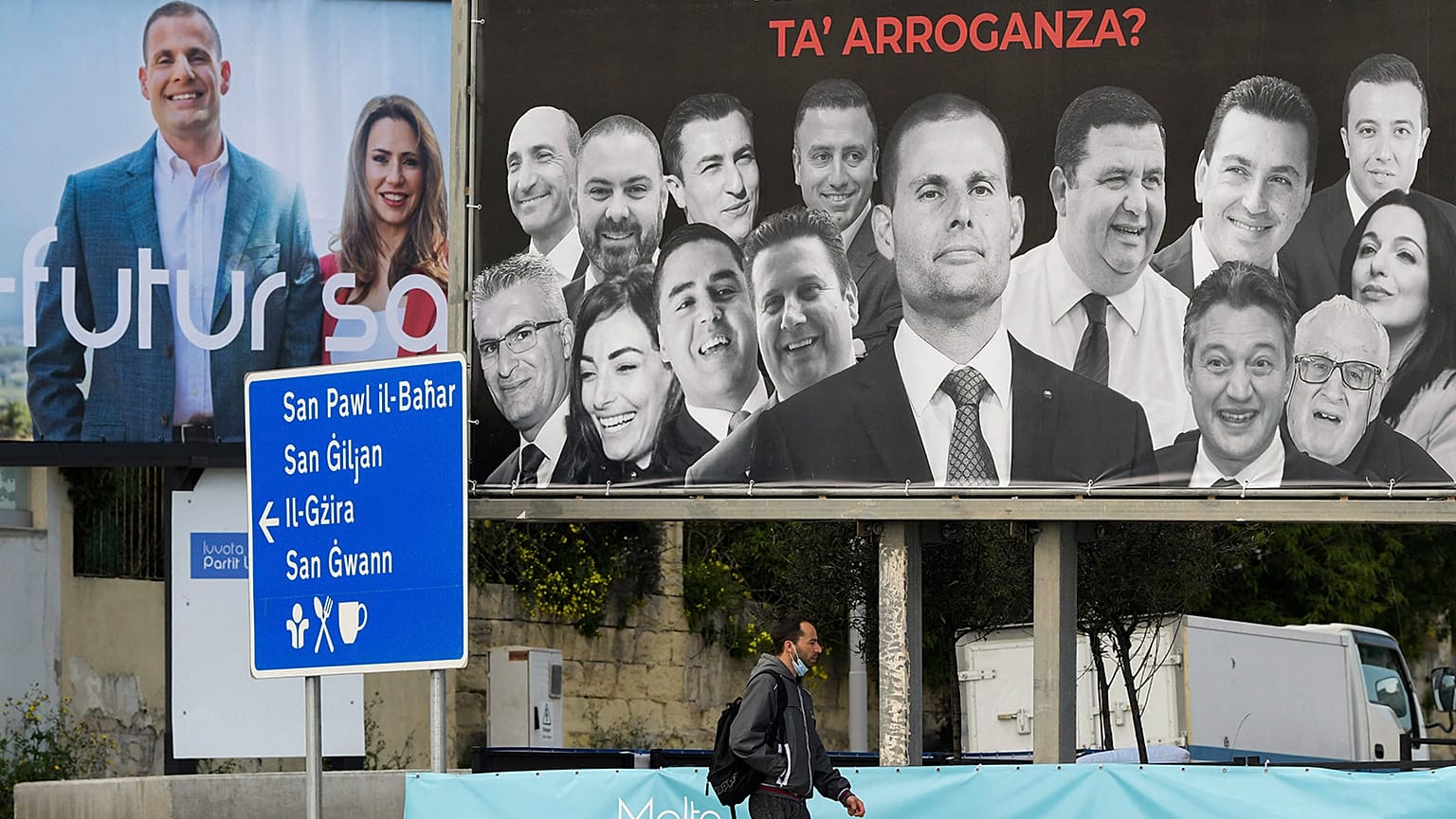 A man walks past election billboards in Msida on 24 March 2022