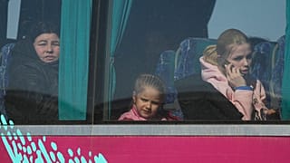 Refugees look out from a bus after fleeing the war from neighbouring Ukraine, at the border crossing in Palanca, Moldova