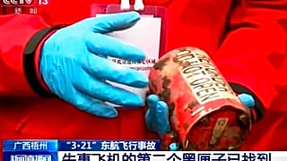 Un miembro de los equipos de búsqueda muestra la segunda caja negra del avión estrellado en China