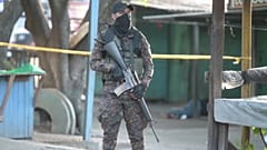 Militar salvadoreño delante del cuerpo de una víctima de la violencia pandillera