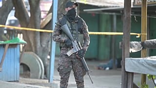 Militar salvadoreño delante del cuerpo de una víctima de la violencia pandillera