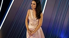Mila Kunis introduces a performance by Reba McEntire at the Oscars on Sunday, March 27, 2022, at the Dolby Theatre in Los Angeles. 