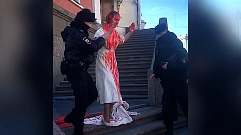 Yevgenia Isayeva escorted towards police van