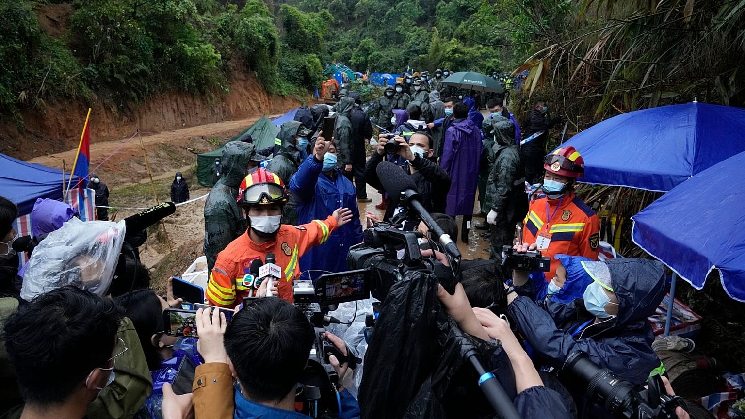 A rescue team member briefs media near the China Eastern crash site Thursday, March 24, 2022, in Molang village, in southwestern China's Guangxi province. 