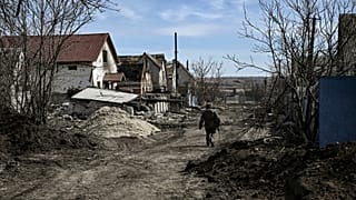 Soldat ukrainien patrouillant dans Mala Rohan, un village à l'est de Kharkiv, repris aux forces russes, le 28 mars 2022 