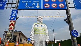 A transit officer, wearing a protective gear, controls access to a tunnel in the direction of Pudong district