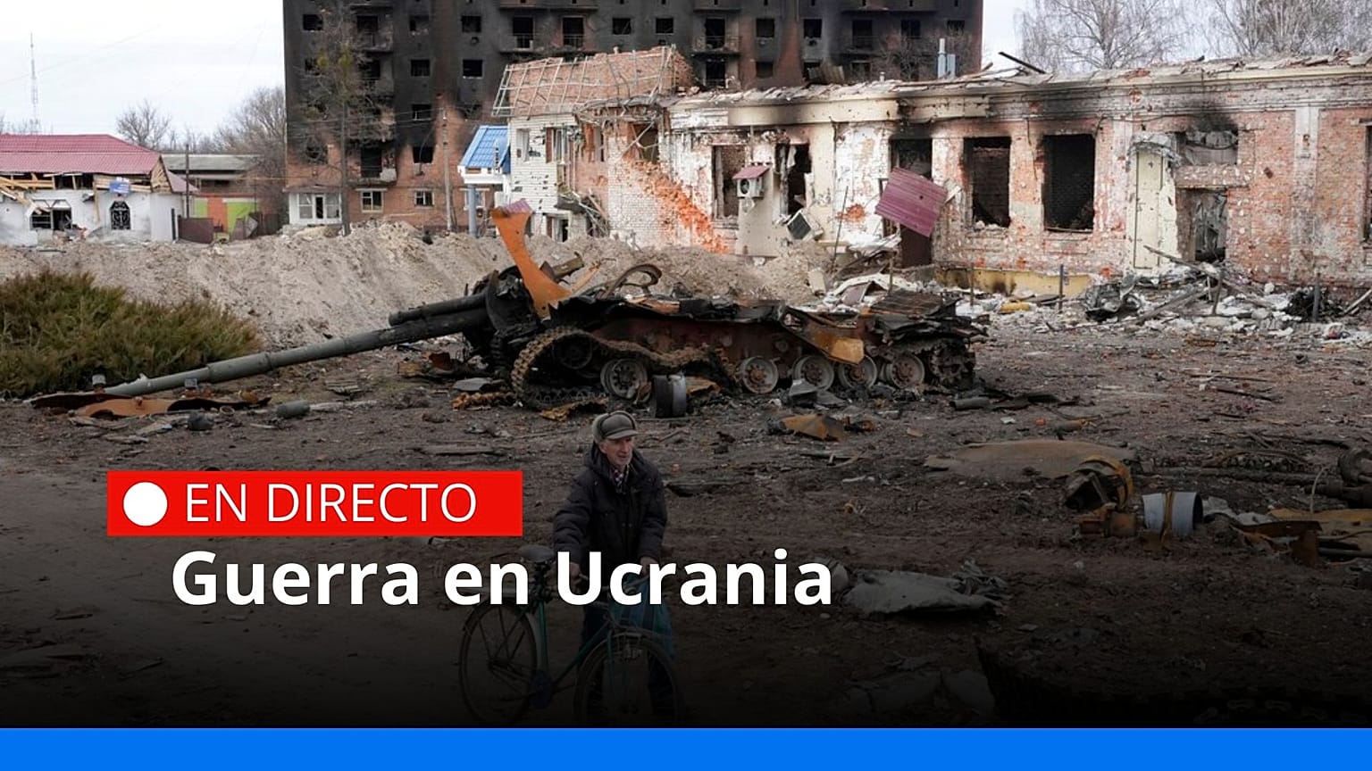 Un residente local paseo con su bicicleta frente a los edificios dañados y un tanque en la ciudad de Trostsyanets