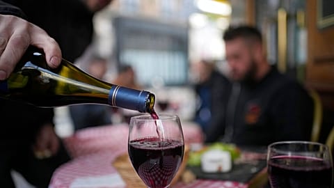 French delight: A customer pours a glass of Beaujolais Nouveau wine in a restaurant of Boulogne Billancourt, outside Paris