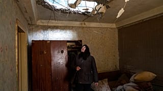 Une dame inspecte les dégâts causés par l'attaque de sa maison près à Brovary, près de Kiyv.