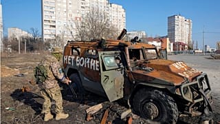 A Ukrainian soldier inspects a destroyed Russian APC after recent battle in Kharkiv, Ukraine.