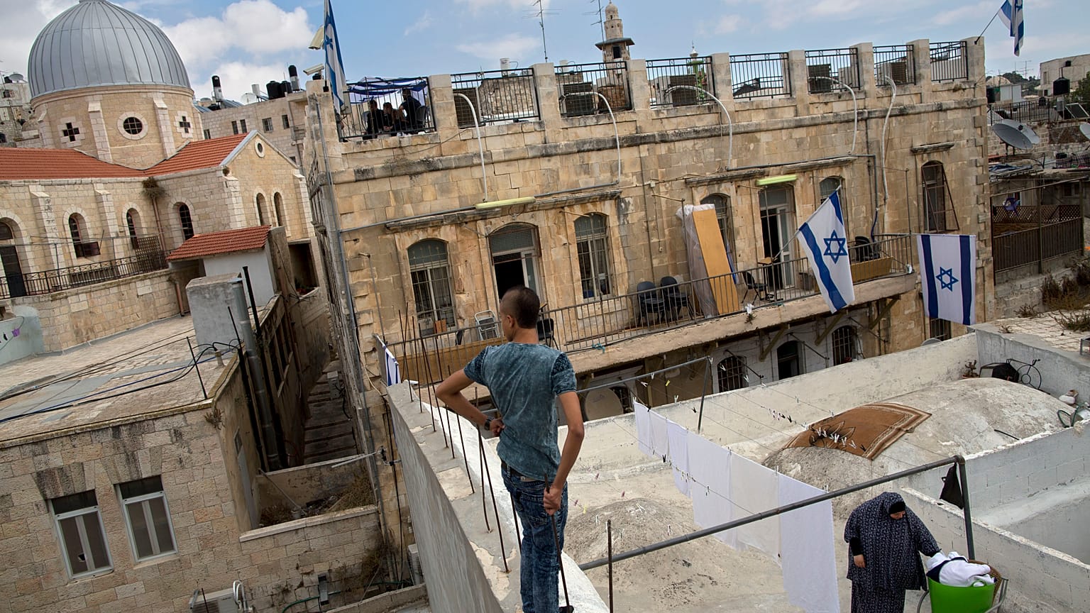 سيدة فلسطينية تنشر الغسيل على شرفتها في البلدة القديمة في القدس المحتلة.