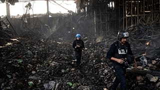 Periodistas caminan por el interior de un almacén destruido para almacenar alimentos, tras un ataque de Rusia hace doce días en Brovary, en las afueras de Kiev, el 29 de marzo