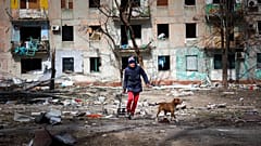 Κάτοικος της Μαριούπολης βγάζει βόλτα τον σκύλο του στα χαλάσματα της πόλης