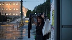 Γυναίκα προσπαθεί να προφυλαχθεί από την ξαφνική νεροποντή στην πλατεία Συντάγματος (φώτο αρχείου)