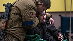 Военнослужащий успокаивает 82-летнюю Ларису Колесник, эвакуированную из Ирпеня