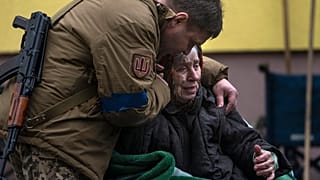 Военнослужащий успокаивает 82-летнюю Ларису Колесник, эвакуированную из Ирпеня