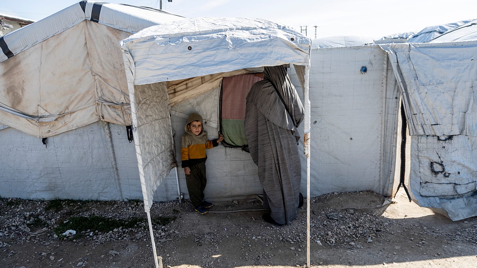 A woman and child stand in the Roj detention camp in northeast Syria.