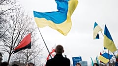A man waves a Ukrainian flag at a Paris demonstration against the Russian invasion.